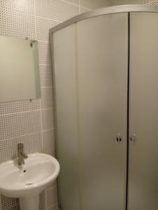 a bathroom with a sink and a glass shower stall at Potemkin view suites in Odesa