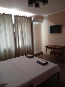 a bedroom with a bed and a table and a television at Potemkin view suites in Odesa