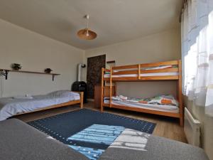 a bedroom with two bunk beds and a rug at Mátra Kulcsosház - Mátraszentimre in Mátraszentimre