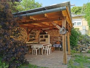 a patio with a table and chairs under a wooden pergola at Mátra Kulcsosház - Mátraszentimre in Mátraszentimre