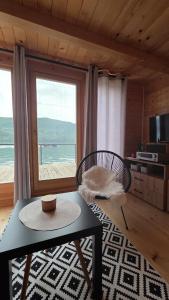 a living room with a table and a view of the ocean at Splav Zaliv, Perućac in Aluga