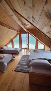 a room with two beds in a room with the ocean at Splav Zaliv, Perućac in Aluga