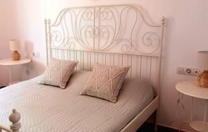 a white bed with two pillows on top of it at Casa Yahshua in Villaverde