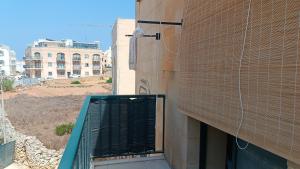 a building with a gate on the side of it at Tan-Nahal Court Apartment, Sannat Gozo in Sannat
