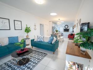 a living room with a blue couch and a table at Ivory Pearl in Paternoster