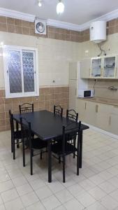 a black table and chairs in a kitchen at شقة ثلاثة غرف نوم وصالة 1 in Al Baha
