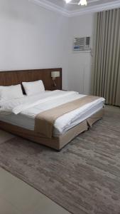 a bedroom with a large bed in a room at شقة ثلاثة غرف نوم وصالة 1 in Al Baha +4 photos