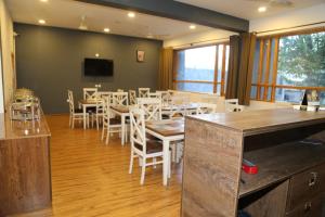 a dining room with tables and chairs and a flat screen tv at Hunza Oriole Hotel in Alīābād +21 photos