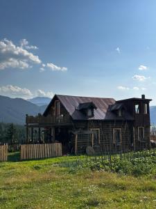 a log cabin in a field with mountains in the background at Boravak Tarhaniš Rožaje in Rožaje