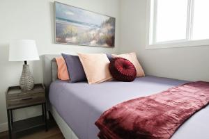 a bed with pillows on it in a bedroom at Central 5 Bedroom AC Rogers Commonwealth EXPO in Edmonton