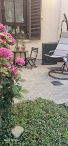 a patio with a chair and a table and flowers at Villa Rosetta in Airasca