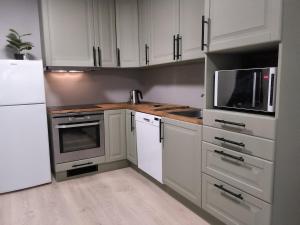 a kitchen with white cabinets and a white refrigerator at Modern 1BR City Centre Apt - Sleeps 4 in Otta