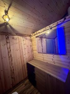 a room with a wooden wall with a blue window at Flori's House in Valbonë