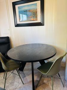ein schwarzer Tisch und Stühle in einem Raum mit einem Gemälde in der Unterkunft Studioflat in centrum in Stavanger + 3 Fotos