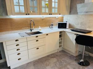 eine Küche mit Spüle und Mikrowelle in der Unterkunft Studioflat in centrum in Stavanger