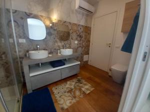 a bathroom with two sinks and a toilet at Casa Linguine in Petacciato +17 photos