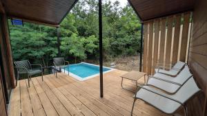 a screened in porch with a swimming pool and chairs at Porto Gumati in Kutaisi
