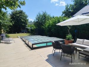 a patio with a pool and chairs and an umbrella at Tallian Lodge in Fonyód