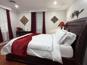 a bedroom with a large bed with white and red sheets at National Harbor Suite 3 in Fort Washington