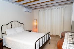 a bedroom with a large white bed and a window at casa maria in La Romana