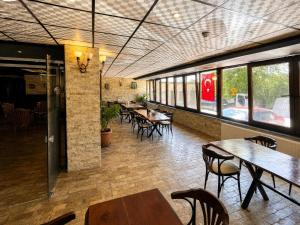 a dining room with tables and chairs and windows at Royal Park Hotel Corlu Bed and Breakfast in Tekirdağ