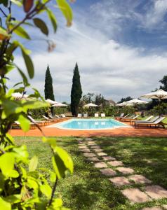 a swimming pool with benches and umbrellas at I Costanti in Caldiero