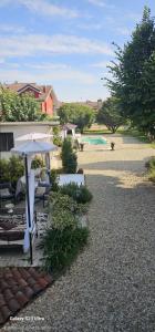 a patio with an umbrella and a swimming pool at Villa Rosetta in Airasca