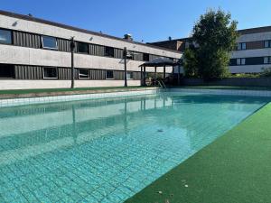 an empty swimming pool in front of a building at First Hotel Halmstad East in Halmstad