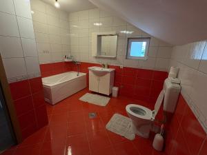 a red and white bathroom with a toilet and a sink at Apartman L&L in Sarajevo +15 photos