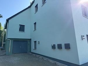 a white building with a door and a garage at Baumannhaus in Ziemetshausen