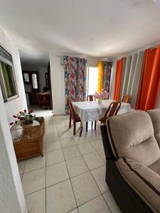 a living room with a table and chairs at Appt Cosy Belcourt in Baie-Mahault +5 photos
