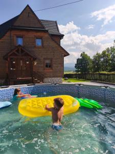 a young boy in the water in a swimming pool at Agroturystyka w Maruszynie in Maruszyna