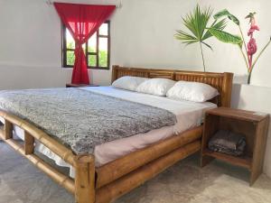 ein Schlafzimmer mit einem Holzbett und einem roten Vorhang in der Unterkunft Great Hostels Amazon in Puyo