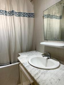 a white bathroom with a sink and a mirror at Sweet Home in Tunis +12 photos