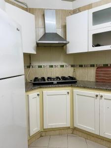 a kitchen with white cabinets and a stove top oven at Sweet Home in Tunis