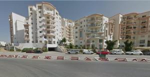 a street with cars parked in front of buildings at Sweet Home in Tunis