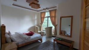 a living room with a bed and a mirror at Cool Pine Hotel Nathia Gali in Abbottabad