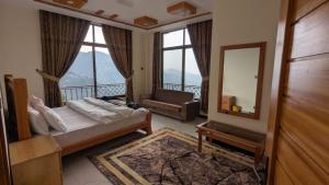 a bedroom with a bed and a mirror and a balcony at Cool Pine Hotel Nathia Gali in Abbottabad
