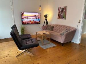 a living room with a couch and a chair at Huset ved springvandet in Randers
