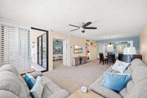 a living room with a couch and a ceiling fan at Beachfront End Unit 302 2 Bikes beach gear in Sanibel