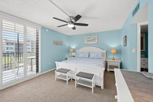 a bedroom with a bed and a ceiling fan at Beachfront End Unit 302 2 Bikes beach gear in Sanibel +62 photos
