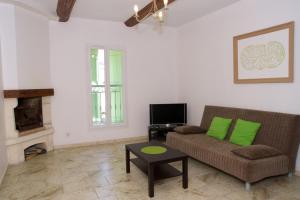 a living room with a couch and a tv at domaine de bessilles in Montagnac