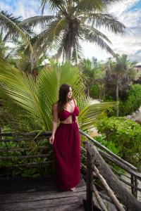 a woman in a red dress standing on a bridge at Playa Esperanza Tulum in Tulum +148 photos
