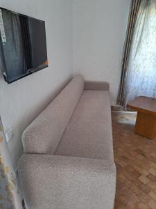 a couch in a room with a tv on the wall at Villa Saif in Marina Smir