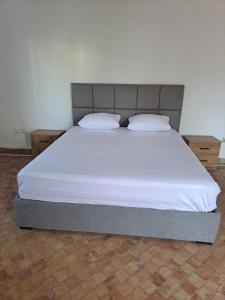a large bed with two pillows on top of it at Villa Saif in Marina Smir