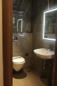 a bathroom with a toilet and a sink at Hotel Nevesa Devanahalli in Bangalore