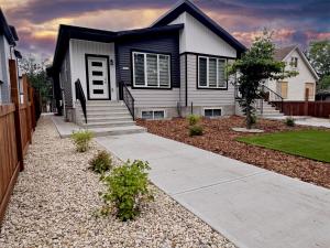 a black and white house with a driveway at Central 3 Queen Beds AC Double Garage Disney in Edmonton