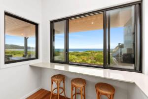 a room with three chairs and a counter with windows at Dunes at Tomakin in Tomakin