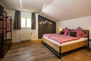 a bedroom with a bed with red and white pillows at Haus Vogl Anger - Ferienwohnungen mit privater Sauna und beheizten Salzwasser Pool in Panoramalage und Nähe zu Salzburg und Berchtesgaden in Anger +123 photos