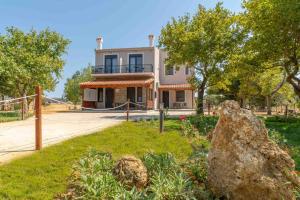 a house with a large rock in front of it at Fragkos Doukas Rooms in Kamariotissa